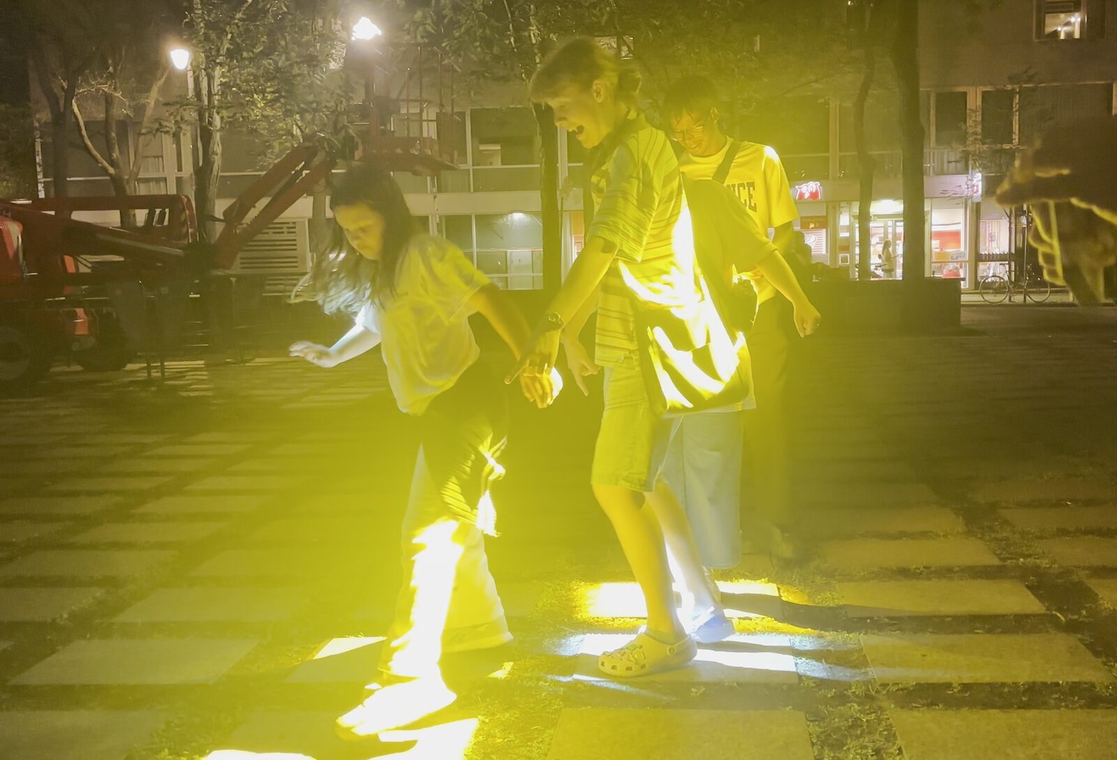 Un groupe de personnes joue avec énergie dans une lumière jaune vif, le soir.