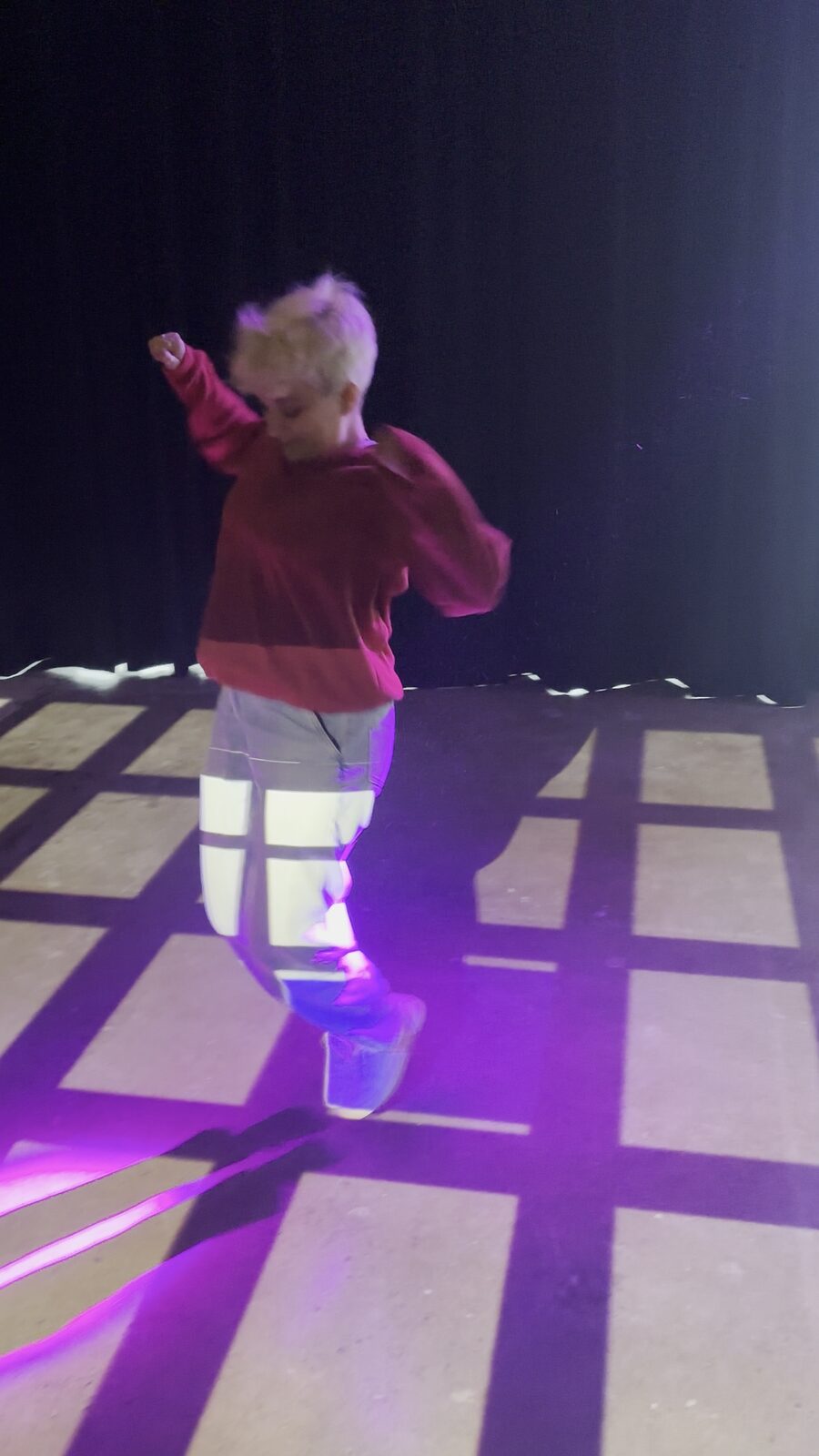 Une personne saute sur des dalles de lumière lors d'un test de jeu, à l'intérieur.